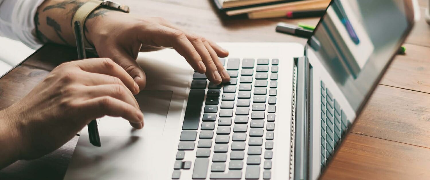 Close up view of a person working on a laptop