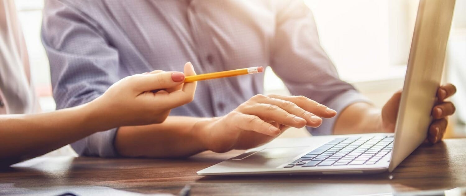 Close up view of two people working on a laptop